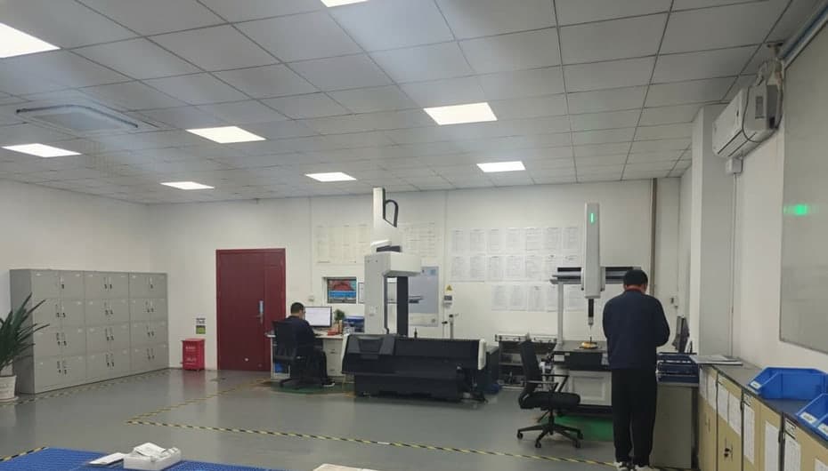 Coordinate measuring machine (CMM) inspecting a manufactured part